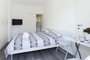 a white bedroom with a bed and a desk at Villa Supuk in Vinišće +35 photos