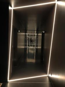 un couloir avec des lumières sur le côté du bâtiment dans l'établissement YUST Antwerp, à Anvers