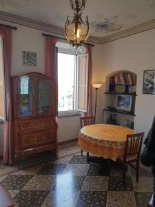 a dining room with a table and a chandelier at House Camogli in Camogli