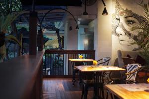 two tables in a restaurant with a face on the wall at Kaniya bali in Nusa Dua