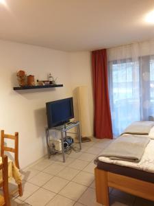 a room with two beds and a flat screen tv at City Appartement 5 in Freiburg im Breisgau