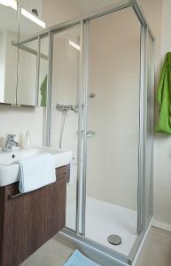 La salle de bains est pourvue d'une douche et d'un lavabo. dans l'établissement Kurhotel Weber, à Bad Wörishofen