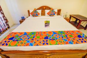 a bedroom with a bed with a colorful bedspread at FabHotel Vinu Valley Resorts - Nr Ketti Valley View Point in Ooty +17 photos