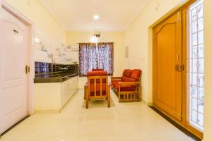 a hallway with two chairs and a table in a room at FabHotel Vinu Valley Resorts - Nr Ketti Valley View Point in Ooty