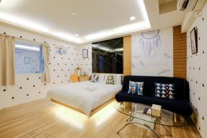 um quarto com uma cama e um sofá em Color Fun inn em Kaohsiung