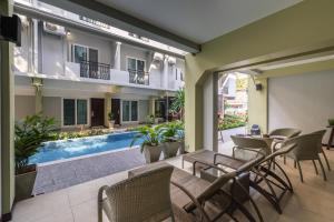 a patio with a table and chairs and a swimming pool at Cozytel Chiangmai in Chiang Mai