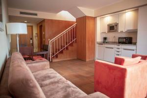 a living room with a couch and a kitchen at Apartamentos Turisticos Atlantida in Funchal
