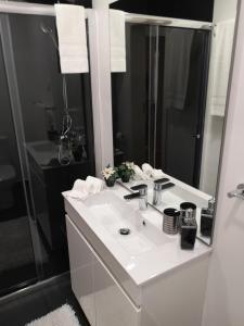 a bathroom with a white sink and a shower at Madeira Inn Casa da Paz in Calheta