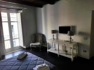 a living room with a tv and a table and a chair at Zelzar Salerno Centro in Salerno