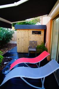 a patio with two chairs and a house at Les Enganes in Fréjus