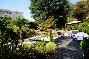 a garden with a table and chairs and an umbrella at Les Enganes in Fréjus +30 photos
