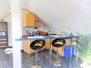 a kitchen with a blue counter and two stools at Ferienwohnung Claudia in Zinnowitz