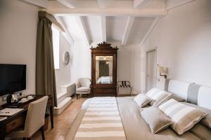 a bedroom with a bed and a desk and a television at Giardini Calce - Luxury Rooms in Ravello