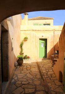 an alley with a green door in a building at Axion Studios in Aroniadika