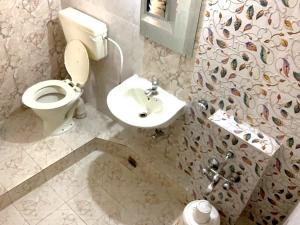 La salle de bains est pourvue de toilettes et d'un lavabo. dans l'établissement Hotel Okasu, à Raipur