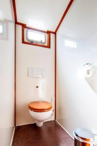 a bathroom with a toilet with a wooden toilet seat at tjalkjacht pelikaan enkhuizen in Enkhuizen