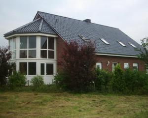 ein Haus mit Dach mit vielen Fenstern in der Unterkunft Ferienwohnung Nordseewatt in Wremen