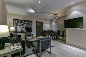 a living room with a couch and a tv at Sun-n-Sand Suites, Shirdi in Shirdi