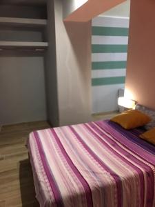 ein Schlafzimmer mit einem Bett mit einer bunten gestreiften Wand in der Unterkunft Suite 01 in Montesarchio