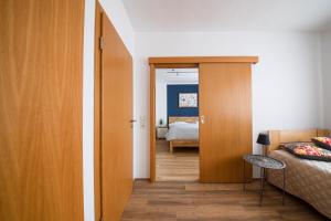 a bedroom with a door open to a bedroom with a bed at Landgasthof Reinert in Reiste