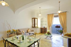 una sala de estar con una mesa y sillas en La Sorgente del Sole, en Positano