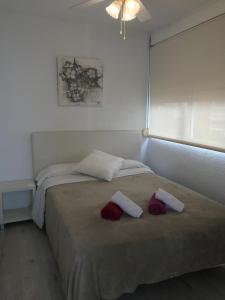 ベニドルムにあるPortofino Suitesのベッドルーム1室(ベッド1台、赤と白のタオル付)