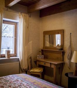 1 dormitorio con cama, espejo y ventana en Grashöfle, en Höhenbrunn