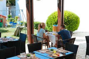 un homme et une femme assis à une table sur un patio dans l'établissement Guest House Pasha, à Ulcinj