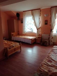 1 dormitorio con 2 camas y ventana en Hadjibulevata Guest House en Kovachevtsi