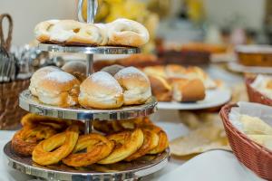 a pile of donuts and pastries on a table at Hotel Euro Suíte Campos do Jordão By Nacional Inn - A 800 metros da Vila Capivari in Campos do Jordão