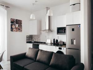 a living room with a couch and a kitchen at Alicante Center Apart in Alicante