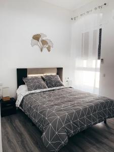 een slaapkamer met een bed met een zwart-wit dekbed bij Alicante Center Apart in Alicante