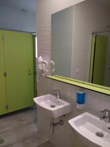 a bathroom with two sinks and a large mirror at Albergue La Magia del Camino in Comillas