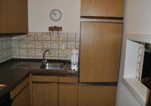 a kitchen with a sink and a clock on the wall at Privat Appartement Primel im Hotel in Bad Gastein