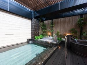 an indoor pool with a bath tub and a bath tub at APA Hotel Pride Akasaka Kokkaigijidomae - Former APA Hotel PRIDE Kokkaigijidomae - National Diet Bldg in Tokyo