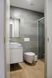 ein Badezimmer mit einem weißen WC und einem Waschbecken in der Unterkunft Antónia's house in Ponte de Lima