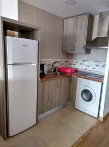 een keuken met een witte koelkast en een wasmachine bij Sunny Beach in Málaga