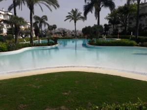 duży basen z palmami w ośrodku wypoczynkowym w obiekcie Chez Elo's Marbella Milla de Oro. Jardin Privado w Marbelli
