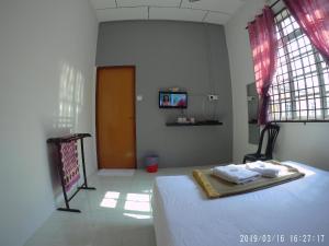 - une chambre avec un lit et 2 serviettes sur un plateau dans l'établissement Semarak Beach Inn, à Dungun