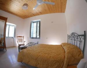 1 dormitorio con cama y techo de madera en La Casa del Miele di Borgo Carbone, en Locri