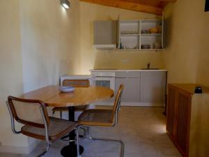 una pequeña cocina con mesa de madera y sillas en La Casa del Miele di Borgo Carbone, en Locri