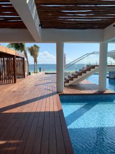 Blick auf einen Pool mit Meerblick im Hintergrund in der Unterkunft La Amada condo with Marina View in Cancún