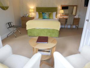 a bedroom with a bed and a table with a laptop on it at Between the Bays exclusively for Adults in Llandudno