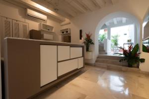 a kitchen with white cabinets and a large window at Delirio Hotel in Cartagena de Indias