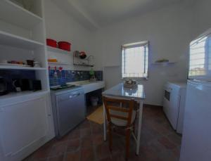 een keuken met een tafel en een kleine tafel. bij La Casetta di Borgo Carbone in Locri