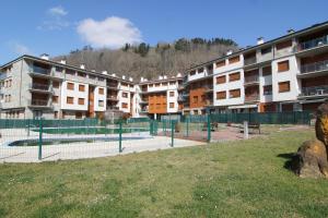 a tennis court in front of some apartment buildings at Jardín del Sella in Cangas de Onís