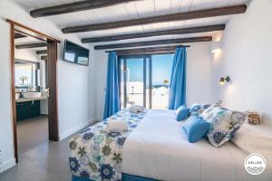a bedroom with a large bed and a large window at Kamezí Boutique Hotel Villas in Playa Blanca