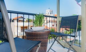 a balcony with two chairs and a potted plant at Hive 68 - Hotel and Resorts (Negombo) in Negombo