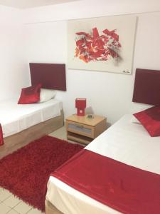 a bedroom with two beds and a red rug at Balaia Residence in Albufeira +20 photos