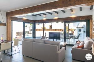 Sala de estar con 2 sofás y TV en Kamezí Boutique Hotel Villas, en Playa Blanca
